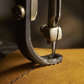 Closeup of sewing machine working part with leather